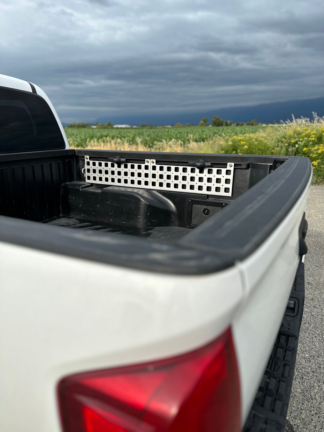 BPF 05-23 Tacoma bed Molle panels installed on a white truck bed, showcasing durable CNC fabricated powder coated panels designed for versatile storage and overlanding gear attachment.